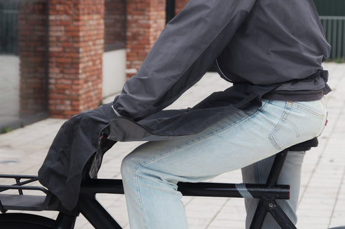 Cyclist wearing the Manta waterproof leg cover over jeans, side view